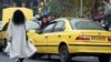 An Iranian woman, not wearing the mandatory hijab, walks in a street in Tehran on December 12, 2024