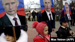 Дети держат портреты президента России Владимира Путина во время митинга в Севастополе. Аннексированный Крым, 23 февраля 2016 года