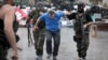 Донецк қаласындағы облыстық әкімдікті басып алған «Восток» батальонының жауынгерлері ресейшіл белсендіні ұстап әкетіп барады. 29 мамыр 2014 жыл. 