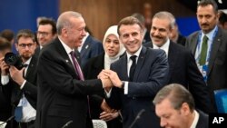 Прэзыдэнт Турэччыны Рэджэп Таіп Эрдаган (зьлева) размаўляе з прэзыдэнтам Францыі Эманюэлем Макронам на пленарным пасяджэньні саміту Эўрапейскай палітычнай супольнасьці ў Будапэшце 7 лістапада 2024 году