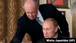 Российский бизнесмен, «повар Путина» Евгений Пригожин (слева) в своем ресторане подает пищу Владимиру Путину, 11 ноября 2011 года (иллюстративное фото)