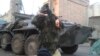 Славянскідегі мал бордақылау зауытына бекінген Украина ұлттық гвардиясының жауынгері курьерлер апарған шұжық пен апельсинді ұстап тұр.