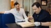 Рыгор Астапеня (зьлева) і Павел Мацукевіч з кнігай Сімяона Полацкага "Жазло кіраваньня".