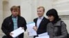 Мікалай Дзямідзенка, Віталь Рымашэўскі і Наста Палажанка паказваюць стосы лістоў з подпісамі.